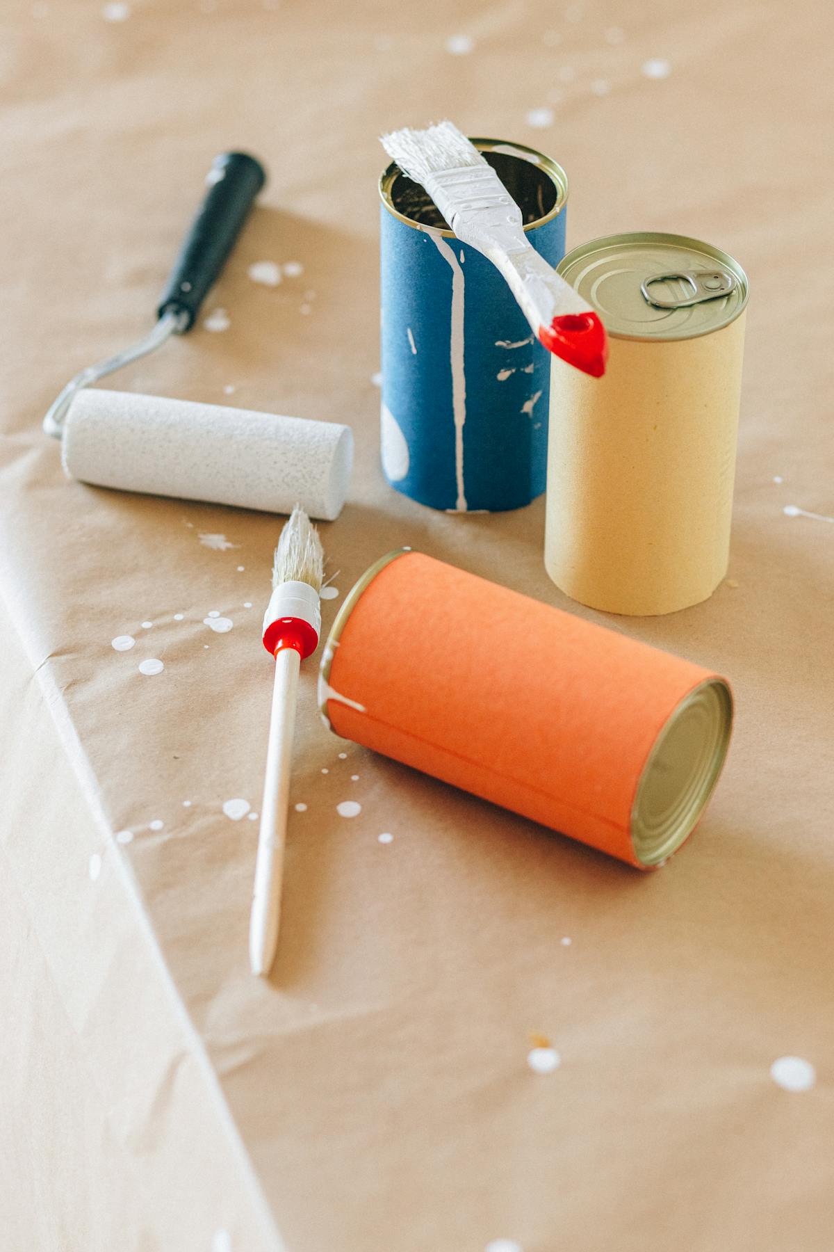 Paint cans and brushes on a drop cloth